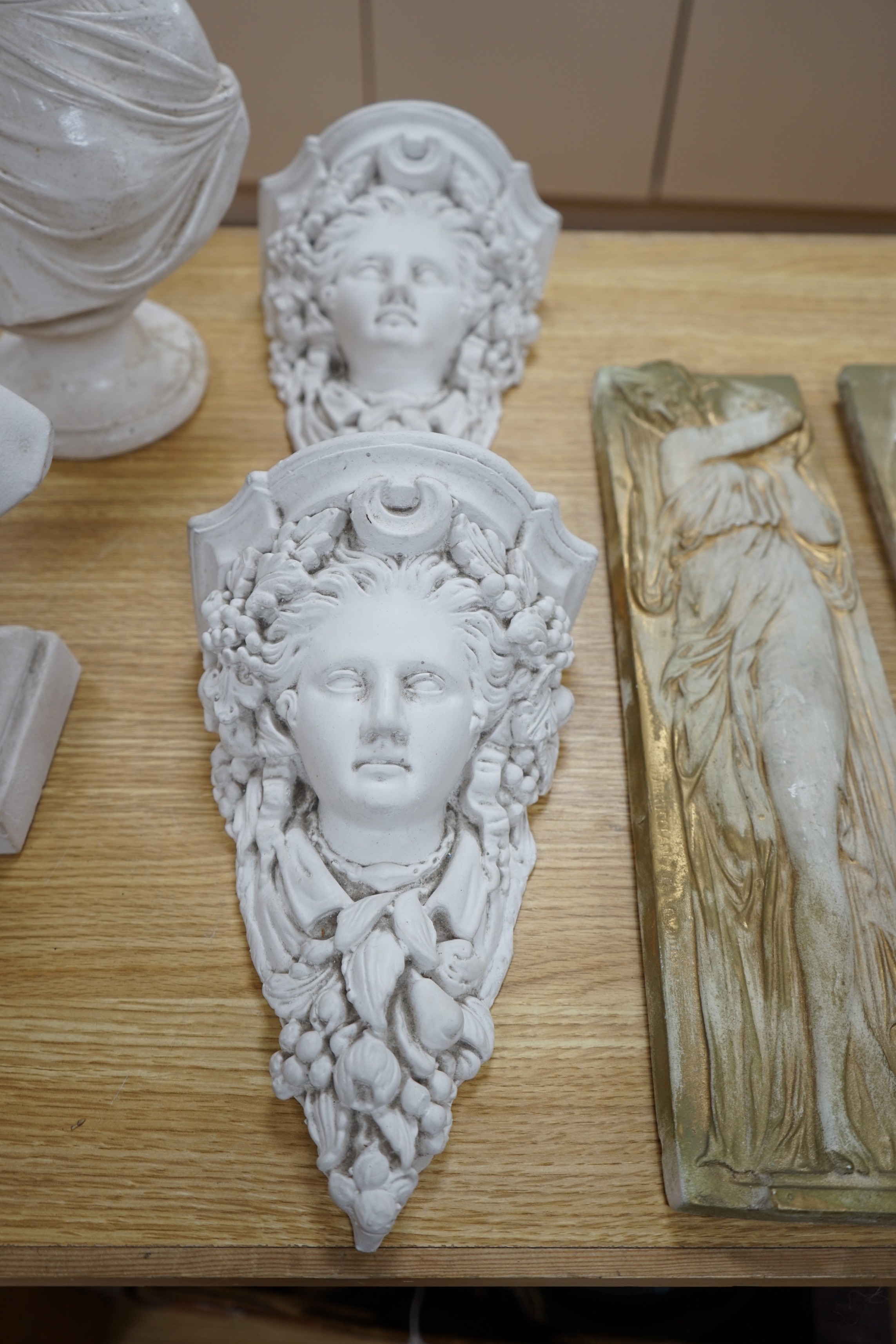 A pair of plaster wall sconces and wall panels, and two busts, tallest 38cms high